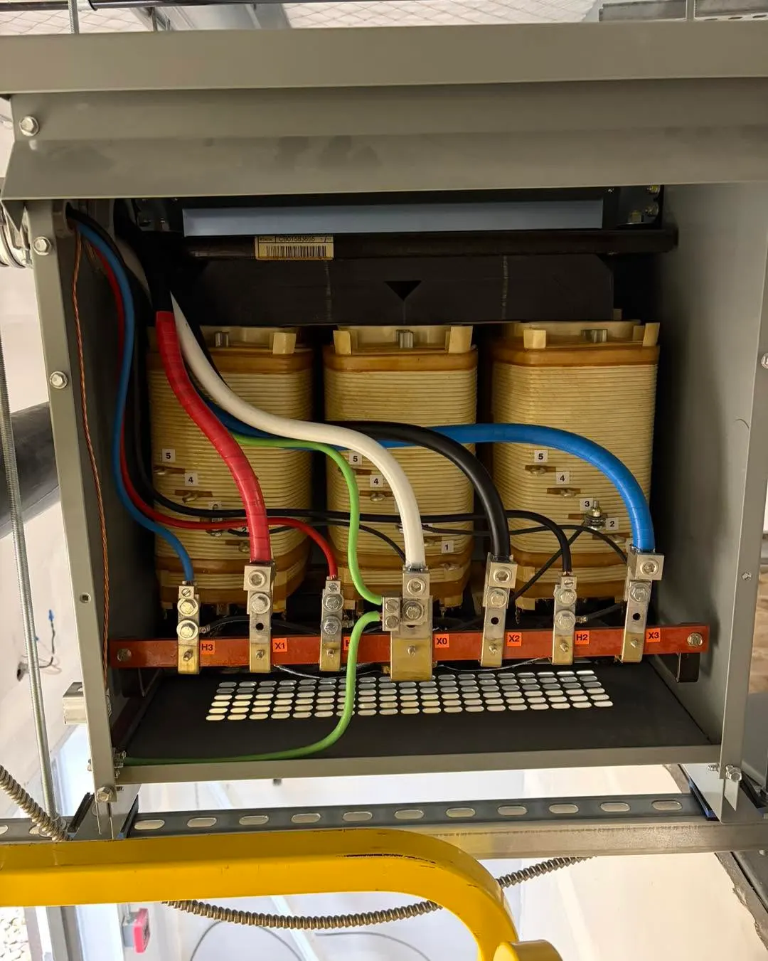 Commercial panel installation with conduit runs entering the top of the enclosure