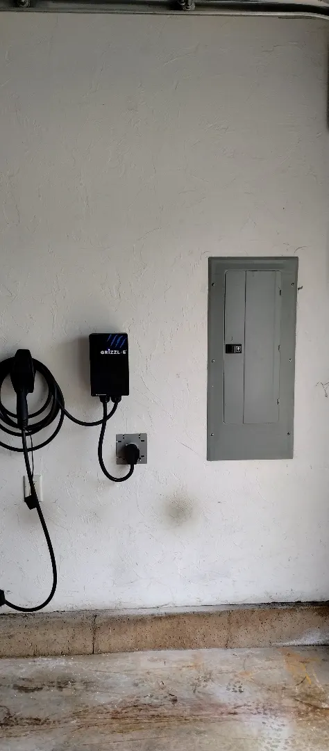Electric vehicle charger installed beside a residential driveway